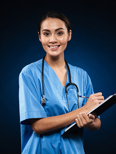 A nurse, smiling, holding a clipboard and stethoscope.